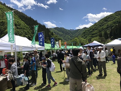 のぼりが立つ沢山のイベントテントと人たち